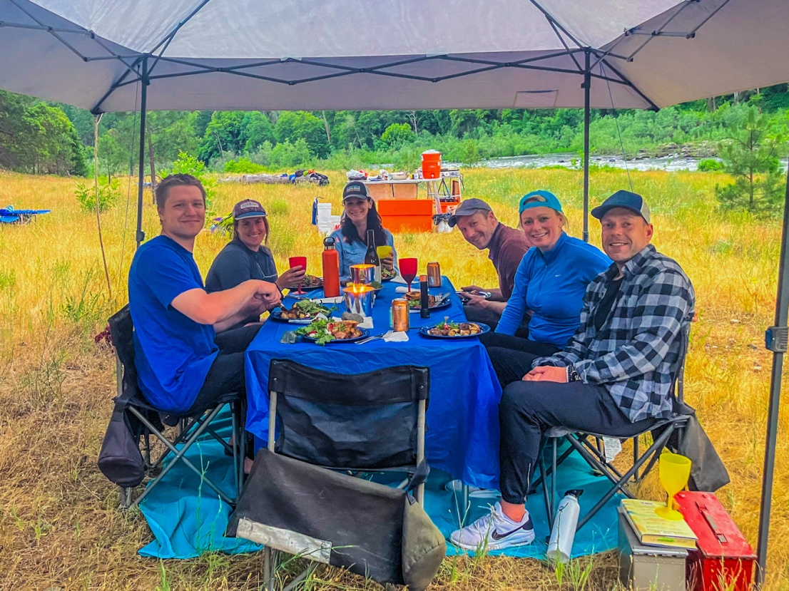 Group having dinner in camp near the Rogue River