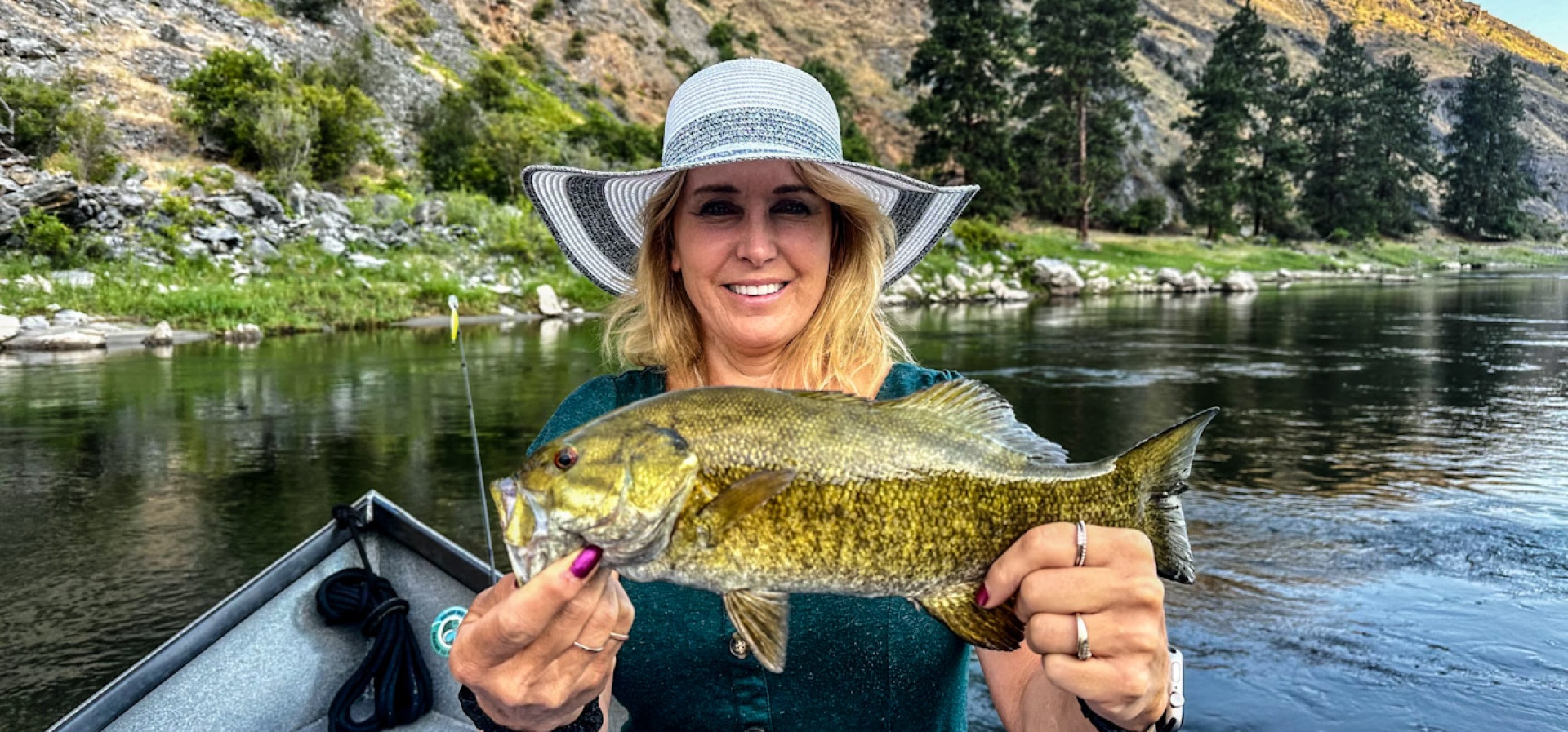 Guest holding a small mouth bass on the salmon River