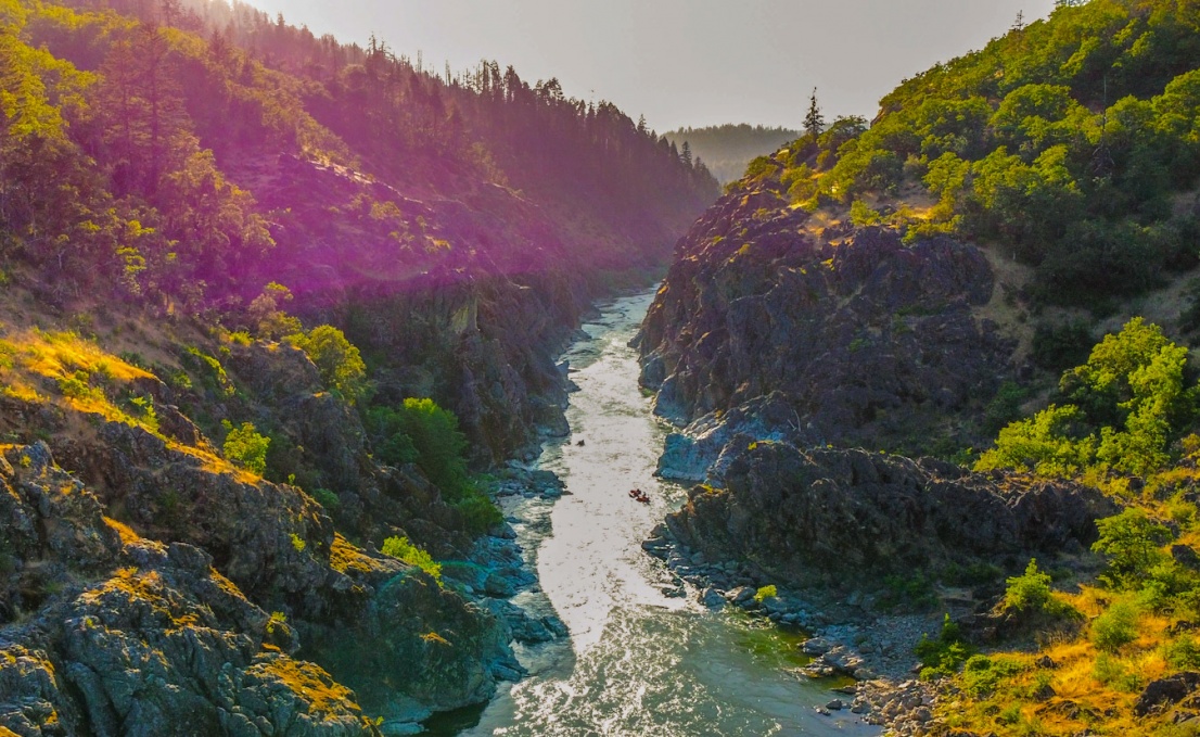 Raft going through hellcat canyon on the Rogue River near sunset taken from above