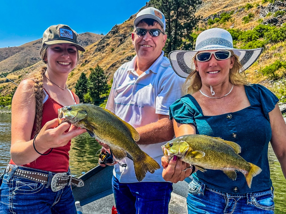 Family holding small mouth bass on the Salmon river