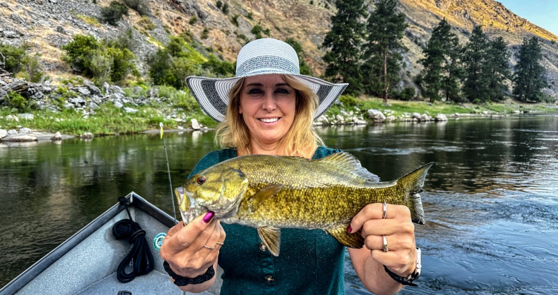 Guest holding a small mouth bass on the salmon river near riggins